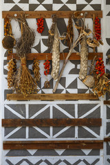 Tomatoes, garlic and herbs drying on a traditionally decorated wall of a house in Pyrgi village on Chios island, Greece.
