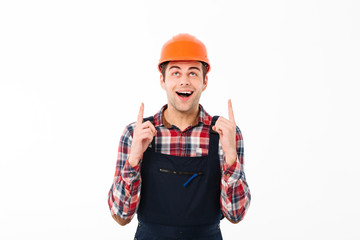 Portrait of a amused young male builder pointing two fingers