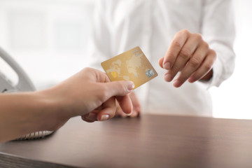 Customer giving credit card to cashier, closeup