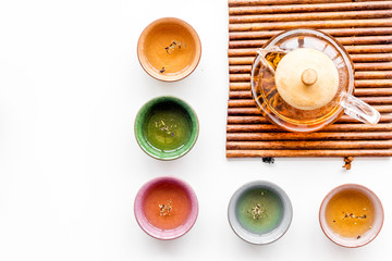 Tea ceremony concept. Tea pot, cups or bowls on white background top view copyspace