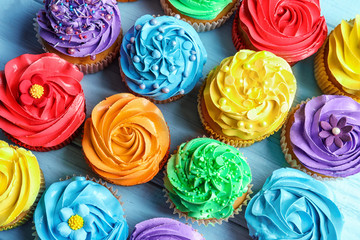 Tasty colorful cupcakes on table