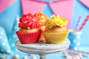 Stand with tasty colorful cupcakes, closeup