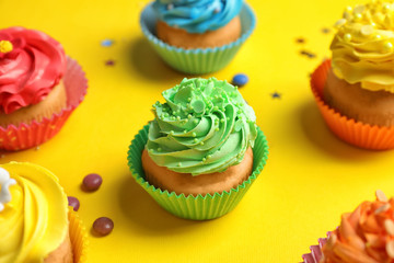 Tasty cupcakes on color background