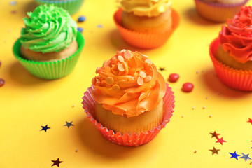 Tasty cupcakes on color background