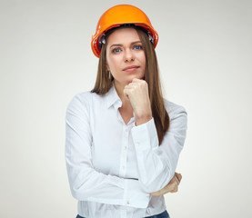 Portrait of thinking business woman wearing builder helmet isolated