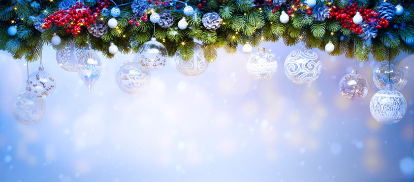 Art Christmas holiday decoration; Fir tree Branches and holiday light on blue snowy background