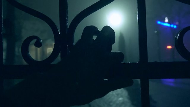 Thief hand of the touches the fence of private possession at night for the purpose of robbery