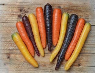 Colorful vegetables. Organic colored yellow, red, orange and purple carrots on a wooden Board. Rustic style