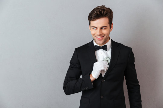 Attractive young waiter holding money.