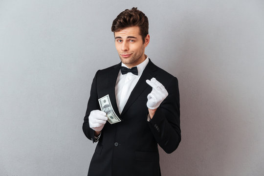 Handsome young waiter while holding money.