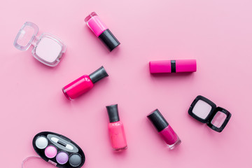 Obraz na płótnie Canvas Cosmetics on colorful background. Bright pink nail polish, lipstick, eyeshadows on pink background top view