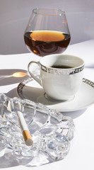 Copa, café y cigarrillo.
Coñac junto al café con un cenicero y un cigarrillo.
