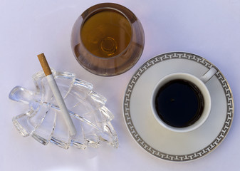 Copa, café y cigarrillo.
Coñac junto al café con un cenicero y un cigarrillo.
