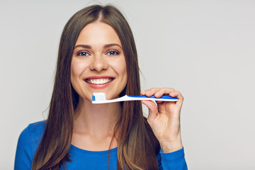 Face portrait of woman smiling with teeth holding toothy brush.