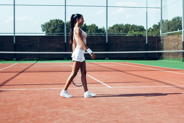 Way to victory. Side view full length of beautiful young woman standing on the tennis court. 