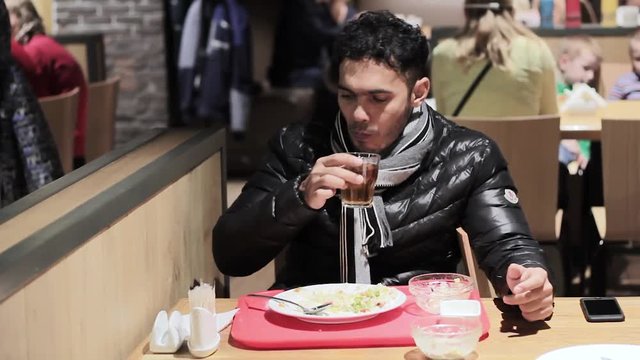 young guy having lunch in a cafe