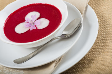 Sopa fría o gazpacho de remolacha rábano cebolla morada y tomate para una comida sana o vegetariana decorada con flor de malva