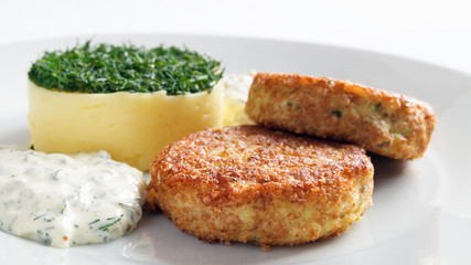 fried fish cutlets, tartar sauce and mashed potato tower decorated with dill