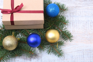 Christmas decoration fir tree with gift box and many balls, on wooden board