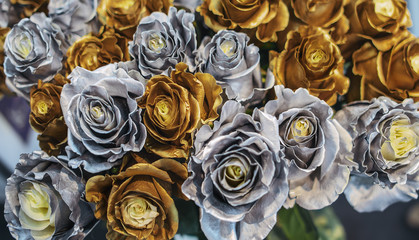 Bouquet of roses with metallic color. Flowers - chameleons with gold and silver petals along the edges.