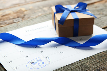 Gift box and calendar list on wooden table. Boxing day concept
