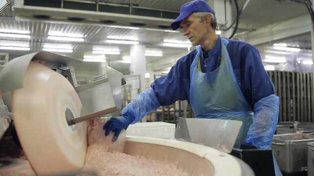 Meat chopper machine, mixing meat and spices for making hot dogs and sausages in a food factory