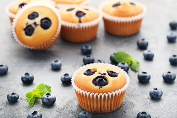 Sweet blueberry muffins on grey wooden table