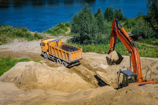 Excavator Loading Sand Into Dumper Truck