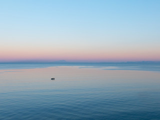 Obraz premium Breathtaking colors of the sunrise, with perfect flat and calm Mediterranean sea. Castellammare di Stabia, Naples, Italy.