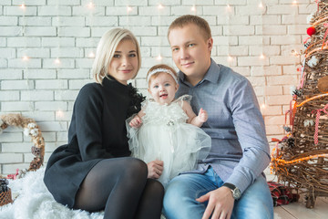 beautiful family at Christmas by the decorated Christmas tree
