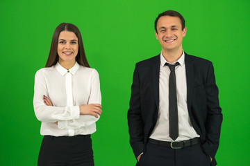 The happy man and woman stand on the green background