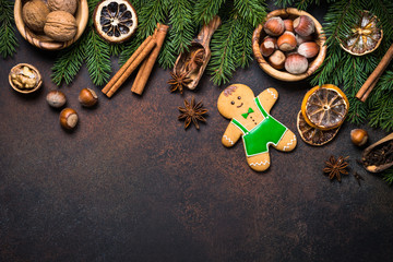 Christmas gingerbread man with spices and nuts. Top view copy space at dark rusty table.