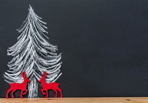 Christmas Tree Drawing on a Black Chalkboard with Deers