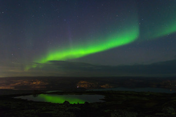 In the night sky the Aurora reflected in a lake.