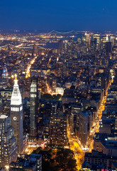Fototapeta premium Aerial view of Manhattan New York skyline at sunset, during the blue hours, with lights of skyscrapers turning on.