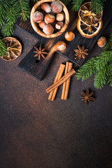 Christmas spices and  nuts on rusty stone table. Christmas baking background.