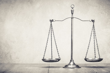 Retro law scales on wooden table. Symbol of justice. Vintage old style sepia photo