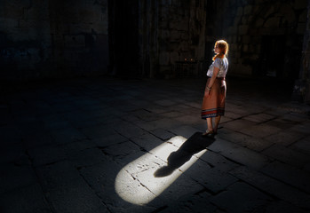 Young woman in natural window light in Sanahin Monastery of Armenia