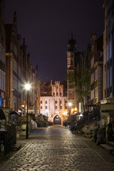 Fototapeta premium View of old buildings on the empty St. Mary's Street (ul. Mariacka) and St. Mary's Gate (Brama Mariacka) at the Main Town (Old Town) in Gdansk, Poland, in the evening.