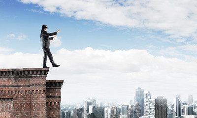Danger and risk concept with businessman making step from edge
