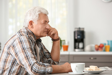 Fototapeta premium Handsome mature man in kitchen