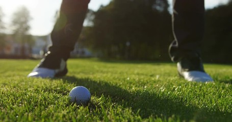Close up of moment the club hitting a ball on the green grass of the golf field. Outdoor. slow motion