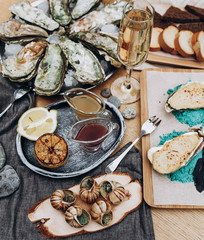 Beautiful serving of oysters, champagne, snails, baked scallops - 180931287