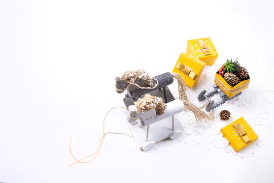 wooden ele toy and yellow boxes with gifts on a white background