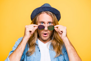 Really? Close up portrait of shocked bearded blond attractive guy holding glasses with fingers,...