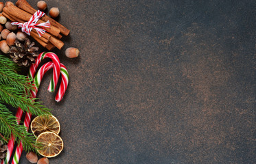 Christmas tree with cinnamon, nuts, candy on a brown background with space under the text.