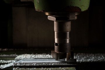 The old milling machine mills the part. There is a dural shaving around it. The working process
