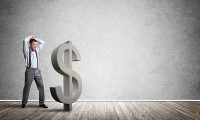 Determined banker man in empty concrete room breaking dollar figure