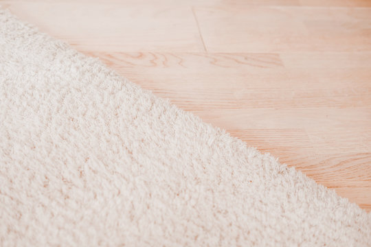 Laminate parquete floor. Light wooden texture. Beige soft carpet. Warm interior design