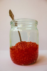 Glass jar with red caviar.